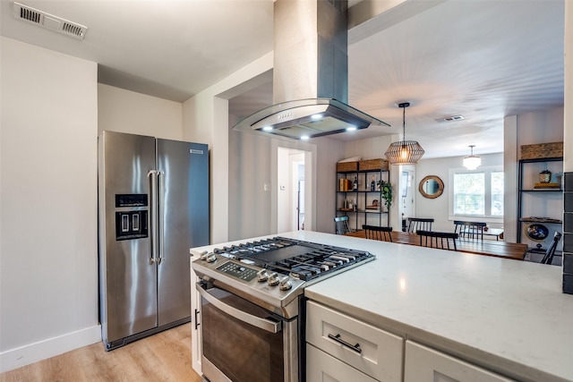 922 S Waverly Dr, Dallas, TX 75208 - kitchen with stainless steel appliances, island exhaust hood, white cabinetry, light wood-style flooring, and pendant lighting