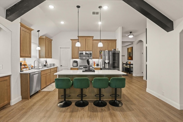 512 Navo Rd, Little Elm, TX 75068 - kitchen featuring stainless steel appliances, decorative backsplash, a center island, light countertops, and arched walkways