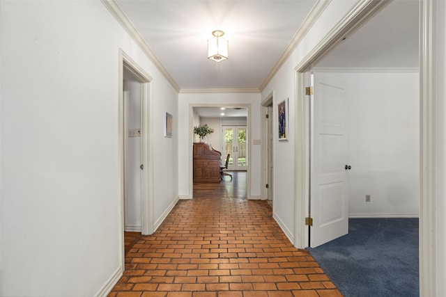 hallway featuring brick flooring, baseboards, and ornamental molding