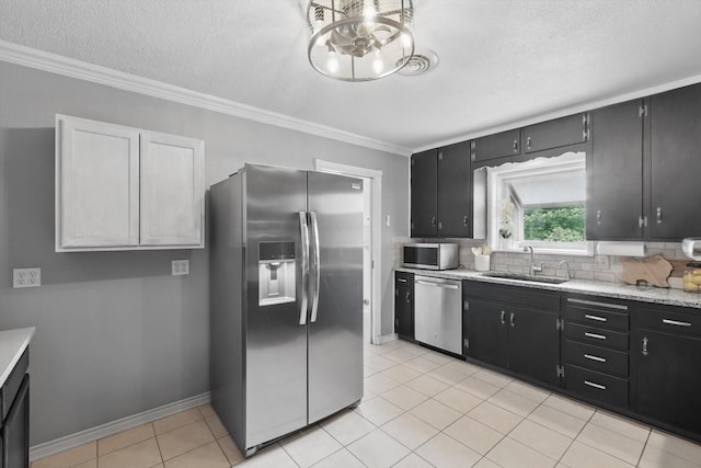 4816 Reynolds Rd, North Richland Hills, TX 76180 - kitchen featuring appliances with stainless steel finishes, a sink, dark cabinets, tasteful backsplash, and crown molding
