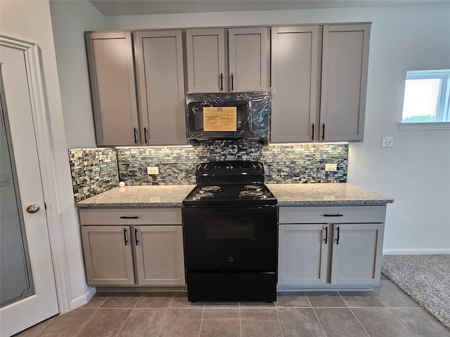 1710 Citrus Dr, Sherman, TX 75092 - kitchen with electric range, gray cabinets, backsplash, and light stone countertops
