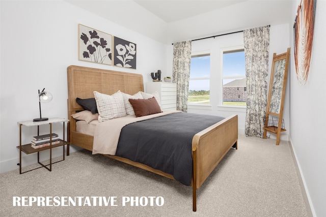 bedroom featuring light carpet and baseboards