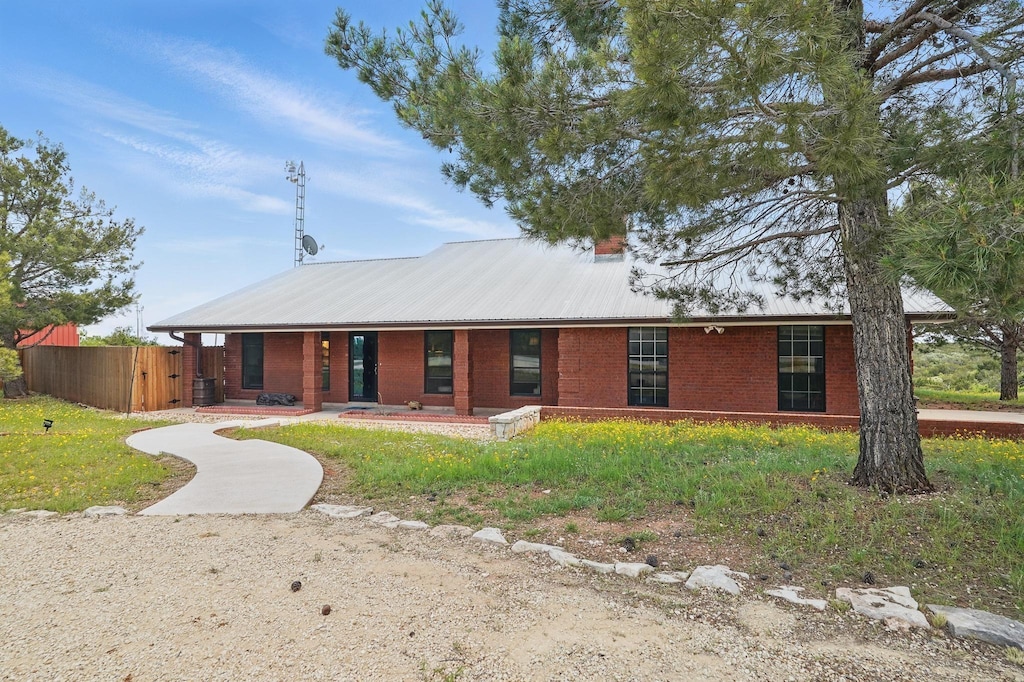 233 Inkman Springs Rd, Sweetwater, TX 79556 - view of front of property with fence, brick siding, and metal roof