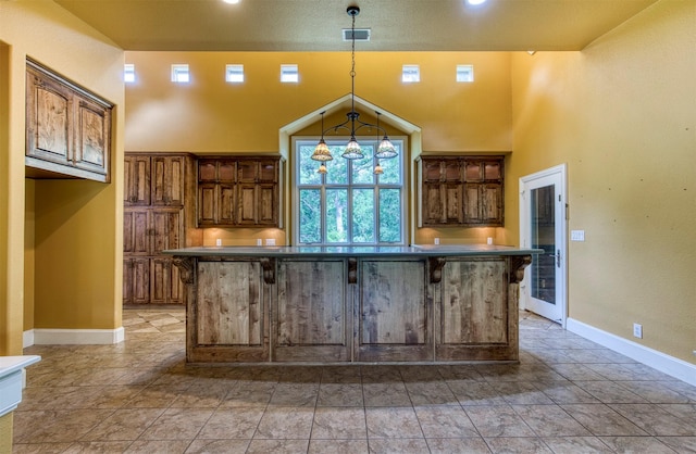 711 Pearl Cv, Oak Point, TX 75068 - kitchen with baseboards, a kitchen island, pendant lighting, a kitchen bar, and a high ceiling