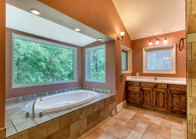 711 Pearl Cv, Oak Point, TX 75068 - bathroom with vanity, a bath, lofted ceiling, and stone tile floors