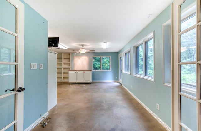 711 Pearl Cv, Oak Point, TX 75068 - unfurnished living room featuring finished concrete flooring, a textured wall, ceiling fan, and baseboards