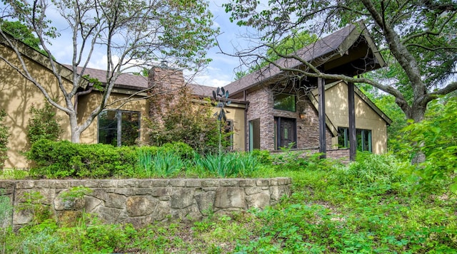 711 Pearl Cv, Oak Point, TX 75068 - view of side of property with stone siding, roof with shingles, and stucco siding