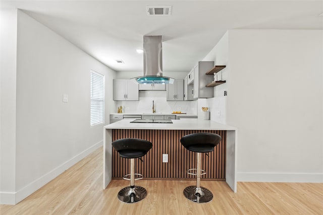 1608 Carolyn St, Irving, TX 75061 - kitchen with island exhaust hood, a breakfast bar, open shelves, and baseboards