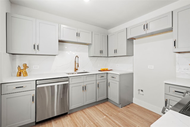 1608 Carolyn St, Irving, TX 75061 - kitchen featuring stainless steel dishwasher, a sink, gray cabinetry, and light wood-type flooring