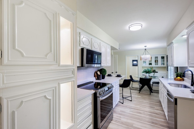 2809 Valley Ridge Dr, Richardson, TX 75080 - kitchen with appliances with stainless steel finishes, a sink, tasteful backsplash, light countertops, and white cabinetry
