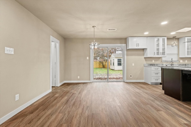 612 S Mills Dr, Euless, TX 76040 - kitchen with baseboards, white cabinets, light wood finished floors, glass insert cabinets, and decorative light fixtures