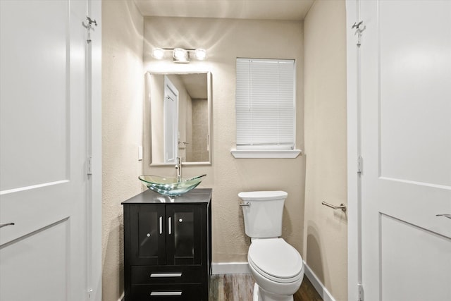 612 S Mills Dr, Euless, TX 76040 - half bathroom featuring wood finished floors, vanity, toilet, and baseboards