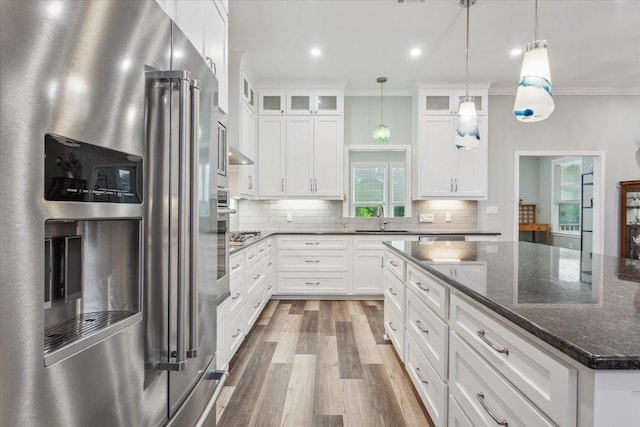 207 Merrifield Dr, Woodway, TX 76712 - kitchen with high quality fridge, a sink, wood finished floors, decorative backsplash, and glass insert cabinets