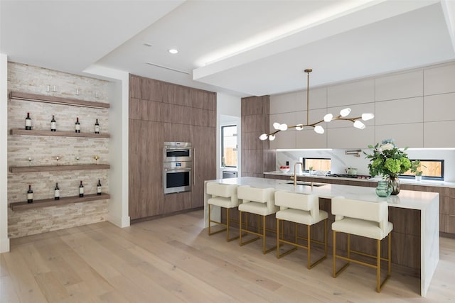 4326 Merrell Rd, Dallas, TX 75229 - kitchen with modern cabinets, a kitchen breakfast bar, brown cabinets, a sink, and recessed lighting