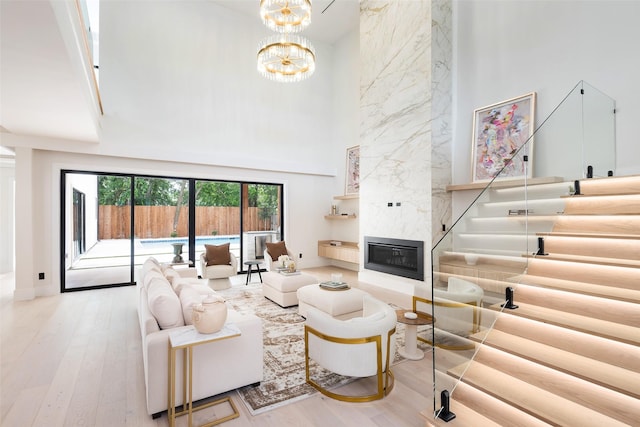 4326 Merrell Rd, Dallas, TX 75229 - living area featuring a towering ceiling, a high end fireplace, wood finished floors, and a chandelier