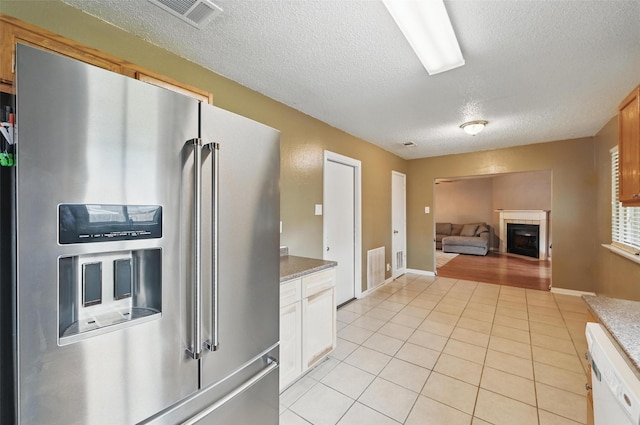 4841 Woodstock Dr, Fort Worth, TX 76137 - kitchen featuring high end refrigerator, a textured ceiling, a fireplace, light tile patterned floors, and dishwasher