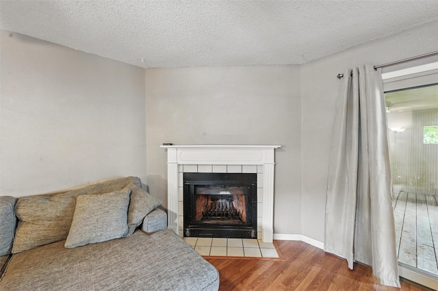4841 Woodstock Dr, Fort Worth, TX 76137 - detailed view of wood finished floors, a tiled fireplace, and a textured ceiling