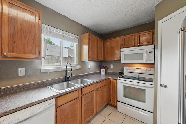 4841 Woodstock Dr, Fort Worth, TX 76137 - kitchen with white appliances, a sink, a textured ceiling, brown cabinets, and light tile patterned flooring