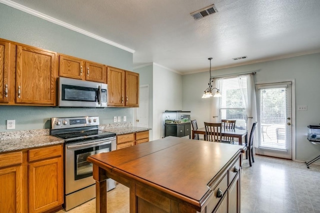3815 Pinebluff Ln, Rockwall, TX 75032 - kitchen featuring stainless steel appliances, brown cabinets, ornamental molding, pendant lighting, and a chandelier