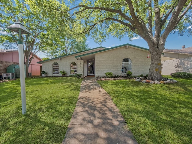 view of front of house featuring brick siding and a front yard
