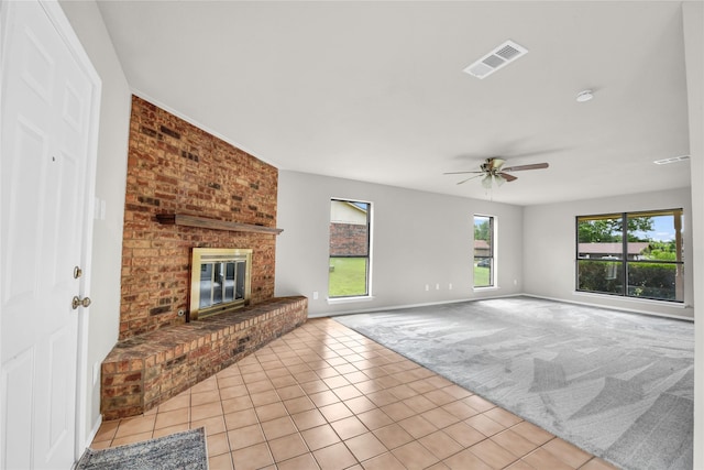 1208 Kay Dr, Weatherford, TX 76086 - unfurnished living room with light carpet, a brick fireplace, ceiling fan, light tile patterned floors, and baseboards