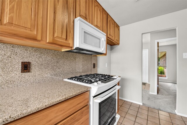 1208 Kay Dr, Weatherford, TX 76086 - kitchen with white appliances, light tile patterned floors, light stone countertops, backsplash, and light carpet