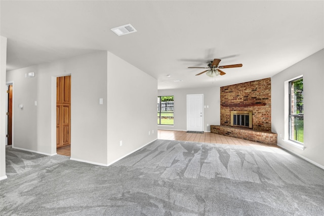 1208 Kay Dr, Weatherford, TX 76086 - unfurnished living room with carpet flooring, a ceiling fan, a brick fireplace, and baseboards