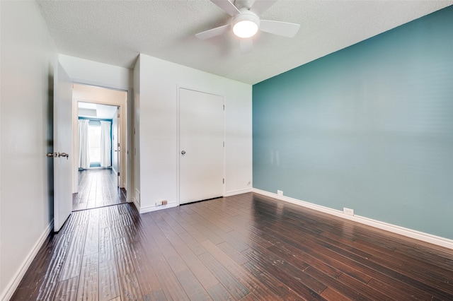 1600 Railhead Pl, Carrollton, TX 75007 - unfurnished bedroom with dark wood-type flooring, baseboards, ceiling fan, and a textured ceiling