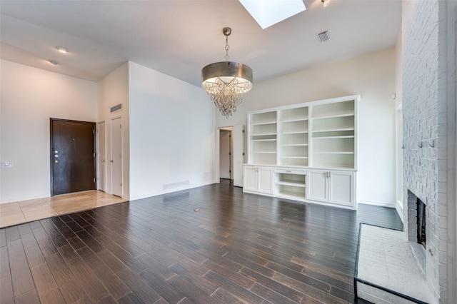 1600 Railhead Pl, Carrollton, TX 75007 - unfurnished living room with a chandelier, a skylight, wood finished floors, a brick fireplace, and baseboards