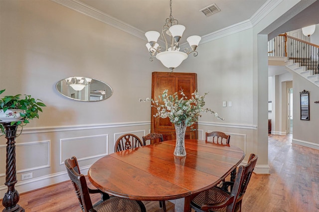 12332 Green Ash Dr, Fort Worth, TX 76244 - dining area featuring stairway, light wood-type flooring, ornamental molding, a chandelier, and a wainscoted wall