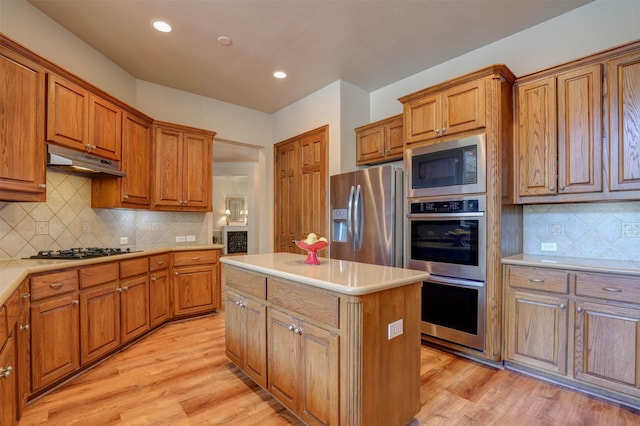12332 Green Ash Dr, Fort Worth, TX 76244 - kitchen featuring stainless steel appliances, under cabinet range hood, brown cabinets, a center island, and recessed lighting