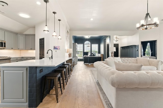 3320 S Fm 548, Royse City, TX 75189 - kitchen with a chandelier, stainless steel microwave, open floor plan, a sink, and a kitchen bar