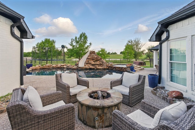 3320 S Fm 548, Royse City, TX 75189 - view of patio featuring a trampoline, an outdoor living space with a fire pit, fence, and a pool with connected hot tub