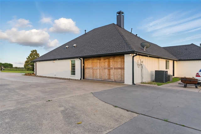 3320 S Fm 548, Royse City, TX 75189 - view of home's exterior with central air condition unit, driveway, a shingled roof, an attached garage, and a chimney