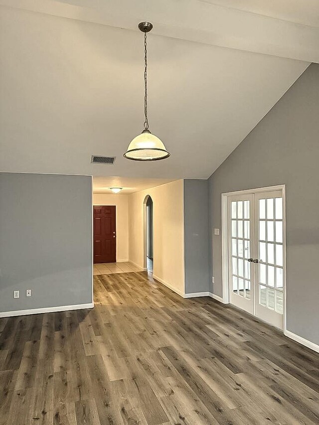 10028 Quail Glen Dr, Fort Worth, TX 76140 - unfurnished dining area featuring arched walkways, lofted ceiling, french doors, baseboards, and wood finished floors