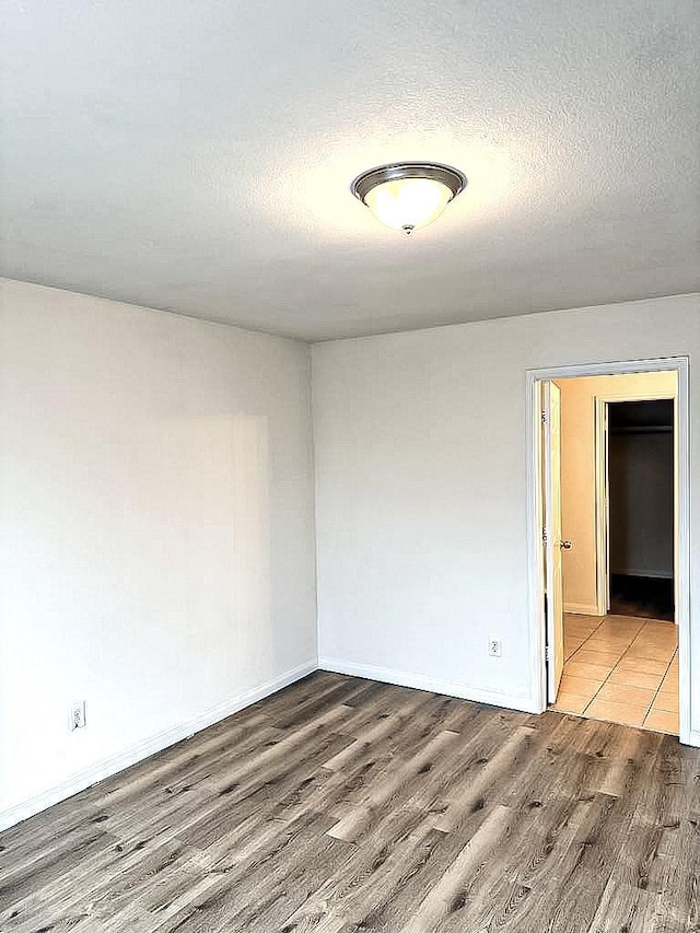 10028 Quail Glen Dr, Fort Worth, TX 76140 - empty room featuring light wood-style flooring, a textured ceiling, and baseboards
