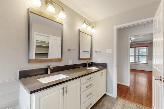 6723 Blessing Dr, Dallas, TX 75214 - bathroom featuring wood finished floors, double vanity, baseboards, and a ceiling fan