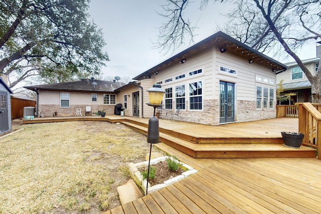 6723 Blessing Dr, Dallas, TX 75214 - back of property with stone siding, cooling unit, and a wooden deck