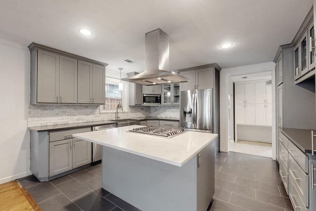 6723 Blessing Dr, Dallas, TX 75214 - kitchen with island range hood, stainless steel appliances, gray cabinetry, a sink, and tasteful backsplash