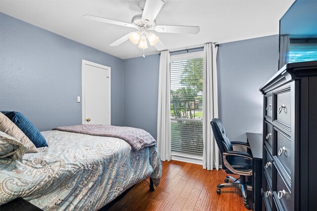 bedroom with hardwood / wood-style flooring, a desk, and a ceiling fan