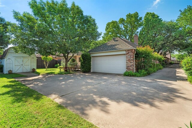 garage featuring driveway and a storage shed