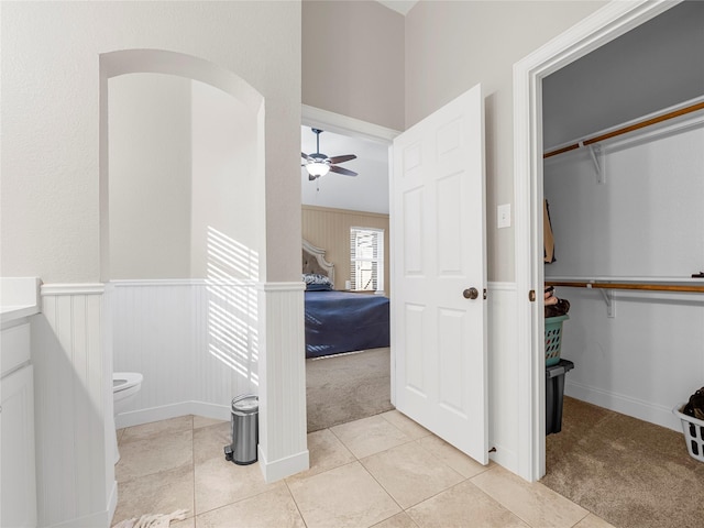 2135 Highland Dr, Wylie, TX 75098 - bathroom featuring a ceiling fan, toilet, tile patterned flooring, a walk in closet, and a wainscoted wall