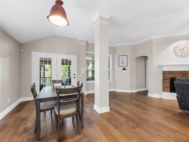 2135 Highland Dr, Wylie, TX 75098 - dining space featuring ornate columns, wood finished floors, crown molding, baseboards, and a brick fireplace