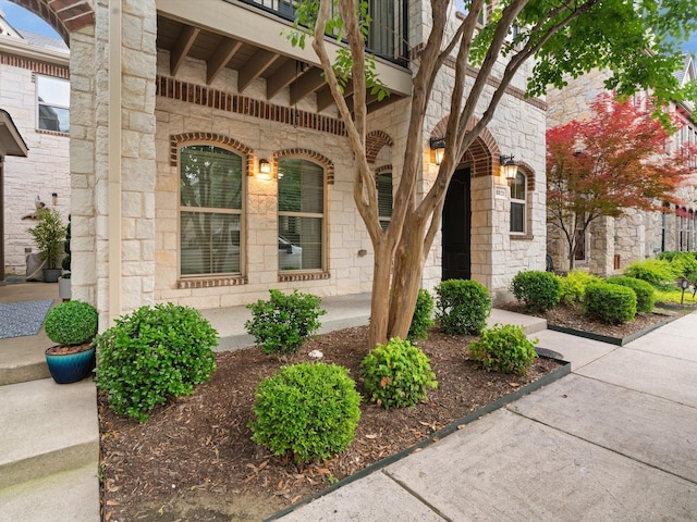 8821 Whitehead St, Mckinney, TX 75070 - view of exterior entry with stone siding, covered porch, and a balcony