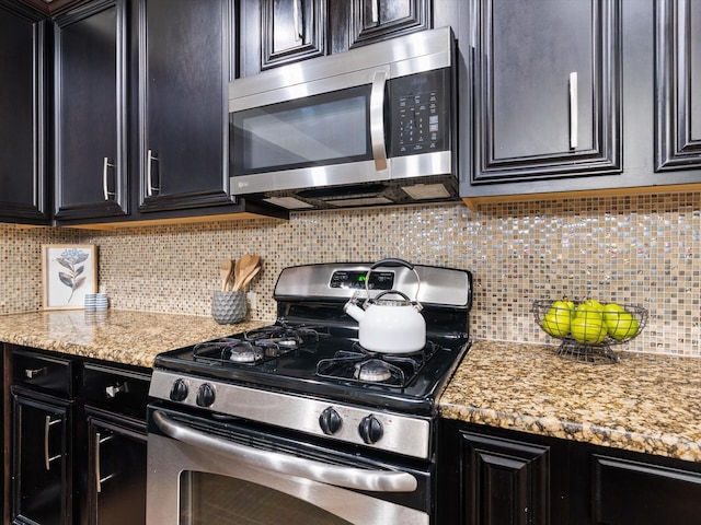 8821 Whitehead St, Mckinney, TX 75070 - kitchen with stainless steel appliances, tasteful backsplash, dark cabinets, and light stone countertops