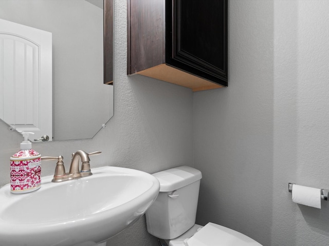 8821 Whitehead St, Mckinney, TX 75070 - half bath with a sink, toilet, and a textured wall