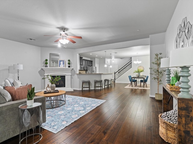 8821 Whitehead St, Mckinney, TX 75070 - living room with a ceiling fan, a chandelier, hardwood / wood-style flooring, baseboards, and a glass covered fireplace