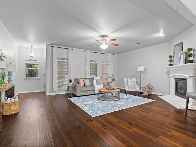 8821 Whitehead St, Mckinney, TX 75070 - living room featuring a ceiling fan, hardwood / wood-style floors, a glass covered fireplace, and baseboards