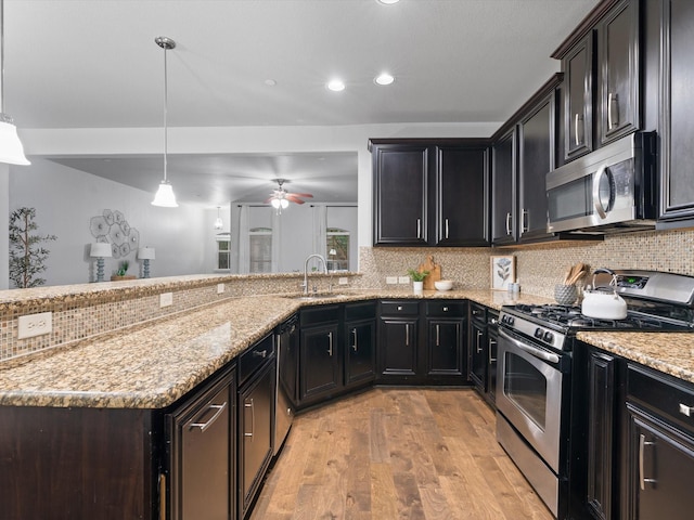 8821 Whitehead St, Mckinney, TX 75070 - kitchen with stainless steel appliances, a sink, light wood-type flooring, decorative backsplash, and a ceiling fan