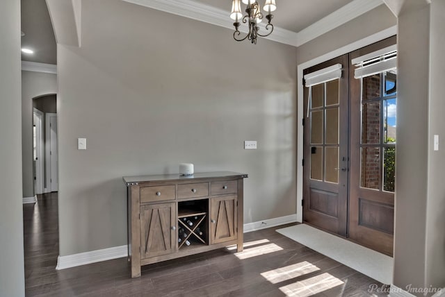 foyer with french doors, arched walkways, crown molding, baseboards, and dark wood-style flooring